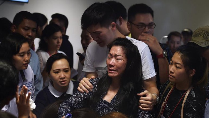 Des familles de passagers du vol AirAsia, disparu dimanche en Indonésie, apprennent le 30 décembre 2014 la découverte de débris de l'avion