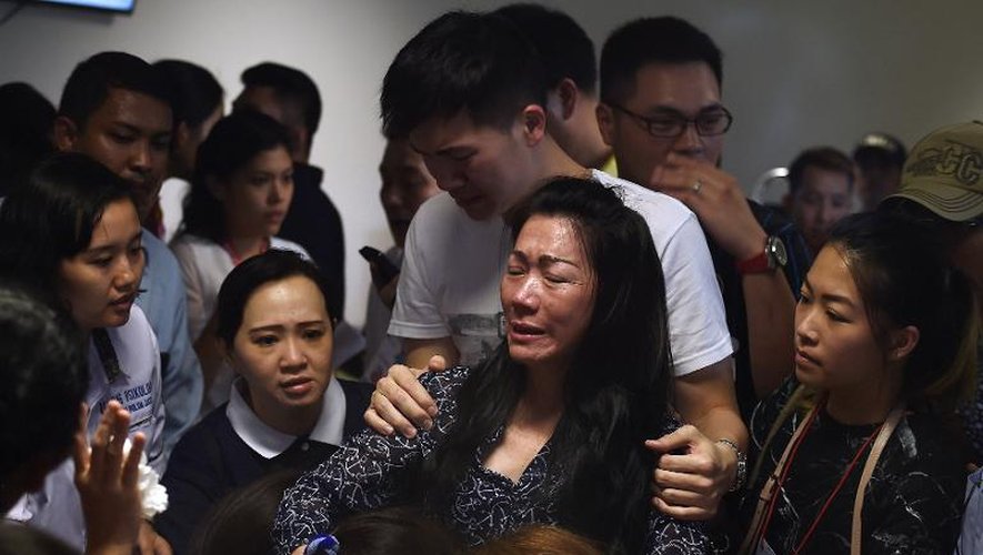 Des familles de passagers du vol Airasia, disparu dimanche en Indonésie, apprennent la découverte de débris de l'avion, le 30 décembre 2014 à Surabaya