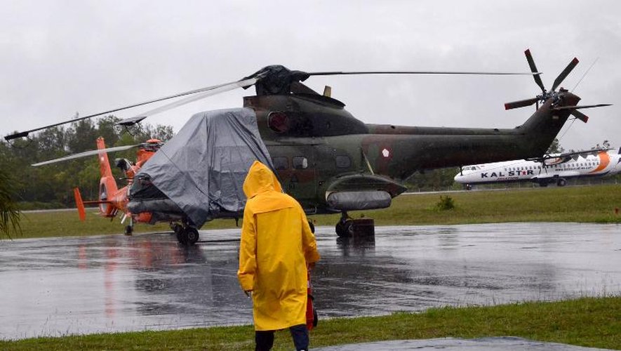 Un hélicoptère clouéau sol sur la base de Pangkalan Bun le 31 décembre 2014 alors que les recherches sont interrrompues en raison du mauvais temps