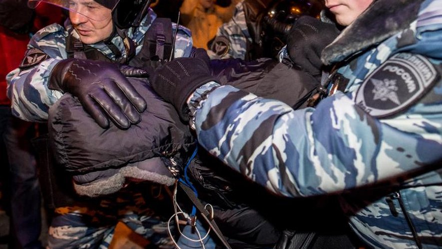 Un manifestant emmené par des policiers, le 30 décembre 2014 à Moscou