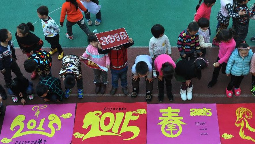 Les enfants d'une maternelle regardent des affiches célébrant 2015 à Linan, dans la province chinoise du Zhejiang, le 30 décembre 2014