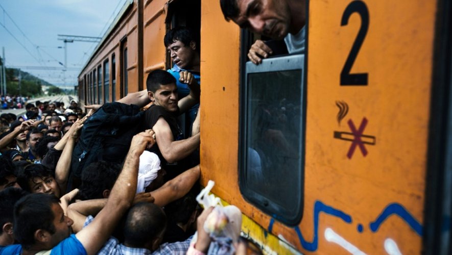 Des migrants tentent de monter dans un train le 5 aoput 2015 à Gevgelija à la frontière entre la Macédoine et la Grèce