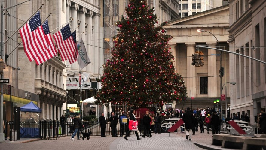 Des gens passent devant un arbre de Noël devant le New York Stock Exchange à New York, le 24 décembre 2013
