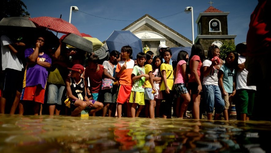 Des gens font la queue à travers les innondations, le 24 décembre 2015 à Calumpit Bulacan, au nord du Manille