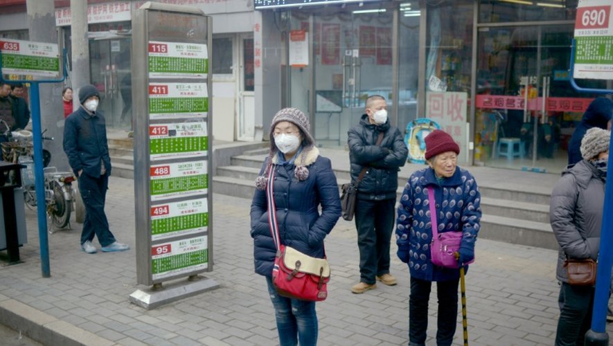 Des passants se protègent de la pollution à Pékin, le 25 décembre 2015