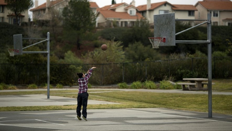 Une femme seule joue au basket-ball, au Holleigh Berson Memorial Park, dans un quartier de Porter Ranch (Californie) où de nombreux habitants ont quitté leur maison après une fuite massive de gaz naturel, dans la vallée de San Fernando, près de Los Angeles, le 22 décembre 2015.