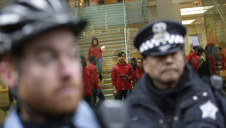 Un policier bloque l'entrée d'un magasin à Chicago, le 24 décembre 2015 lors d'une manifestation contre les violences policières