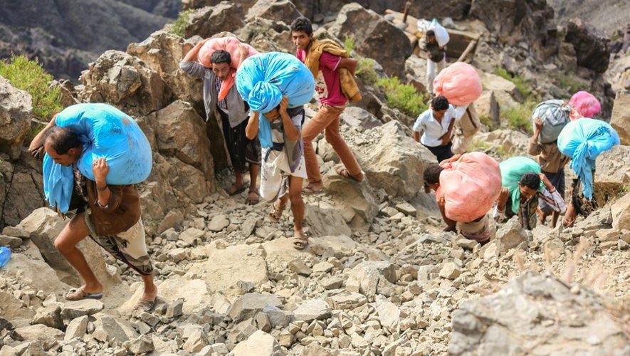 Des gens transportent de la nourriture sur la seule route entre Aden et Taëz, dans le sud-ouest du Yémen, le 26 décembre 2015