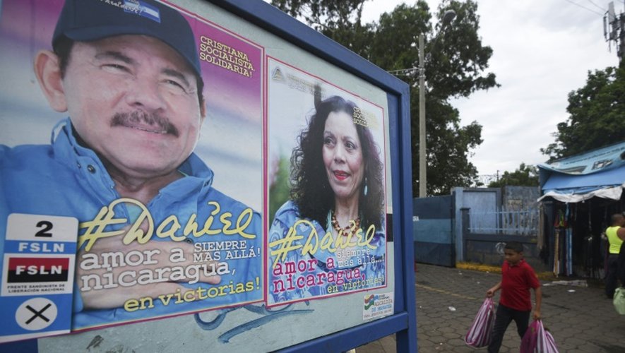 Un garçon passe près des afffiches de campagne du couple Ortega, le 2 novembre 2016 à Managa