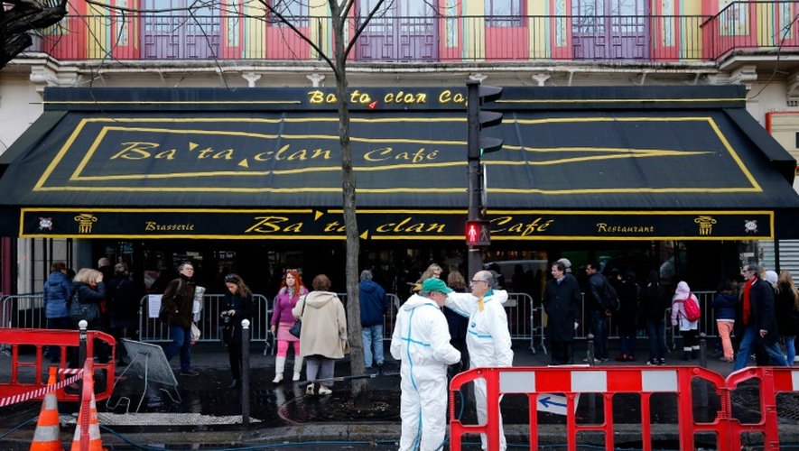 Des agents municipaux nettoient la façade et le trottoir devant le Bataclan à Paris, le 22 décembre 2015