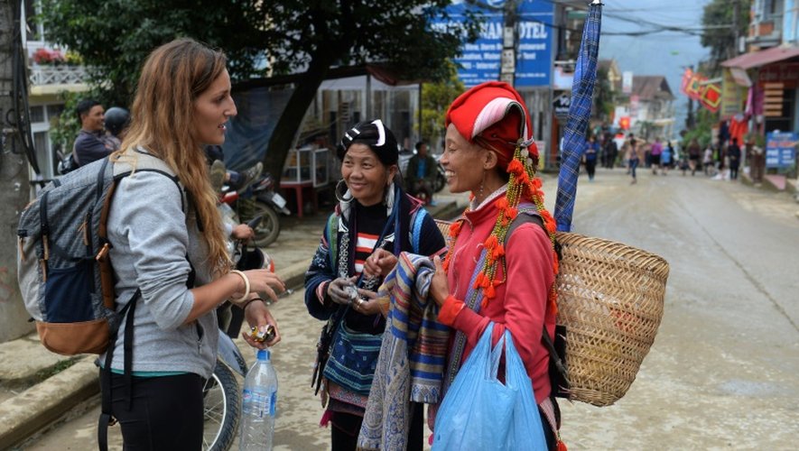 Des Vietnamiennes vendent des souvenirs à une touristes dans le village de Sapa, au Vietnam, le 1er octobre 2016