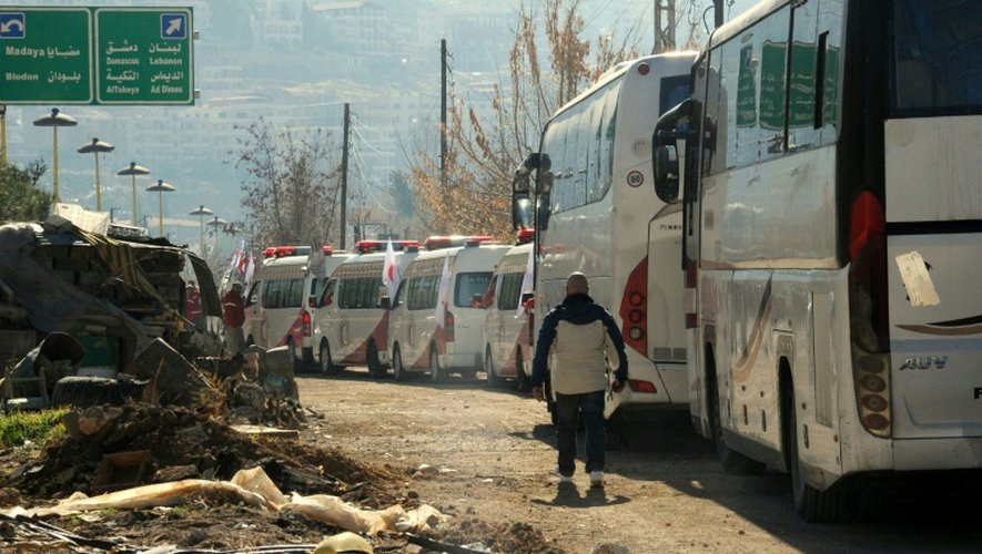 Photo fournie par l'agence Sana montrant des ambulances de la Croix rouge syrienne et des bus au poste frontière de Zabadani pour évacuer des civils, le 28 décembre 2015