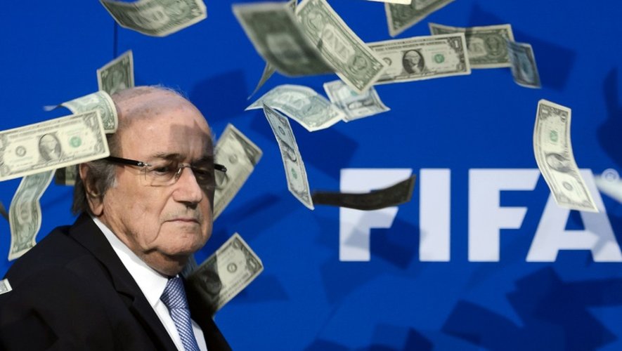 L'ancien président de la FIFA, Sepp Blatter se fait lancer des faux billets de dollars par des protestataires lors d'une conférence de presse à Zurich le 20 juillet 2015
