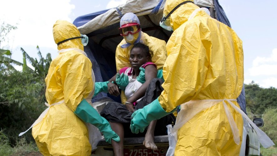Des soignants évacuent le 21 novembre 2014 à Macenta en Guinée une femme atteinte par le virus ebola