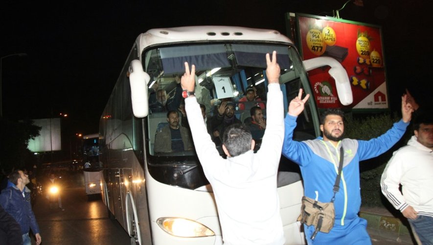 Des bus transportant des Syriens évacués de deux localités assiégées par les rebelles transitent par Beyrouth le 29 décembre 2015