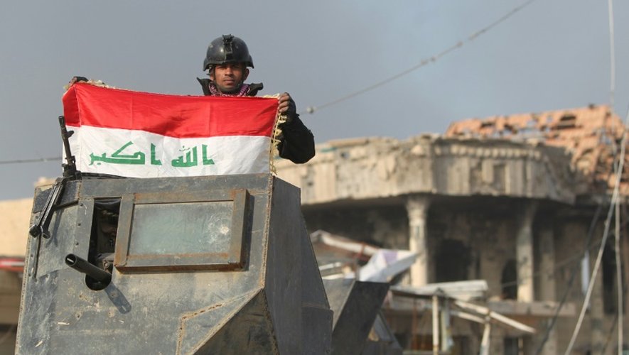 Le drapeau national irakien brandi par un membre de l'unité anti-terroriste le 28 décembre 2015 à Ramadi