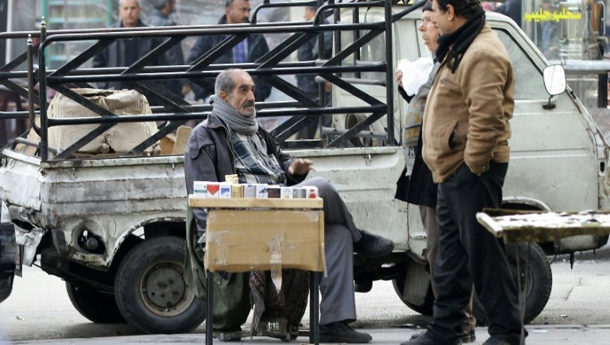 Le Syrien Abou Zyad vend des cigarettes assis devant son pick-up à Damas, le 17 décembre 2015