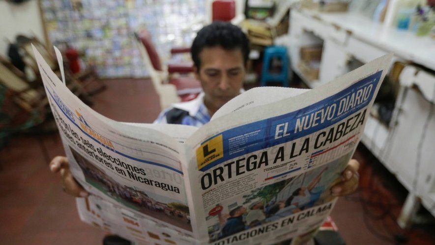 Un homme lit le journal dont la "Une" annonce la réélection du président Daniel Ortega, le 7 novembre 2016 à Managua, au Nicaragua