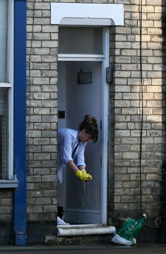 Une femme presse une éponge pendant le nettoyage de sa maison, après les innondations dans la ville de York au nord de l'Angleterre le 29 décembre 2015