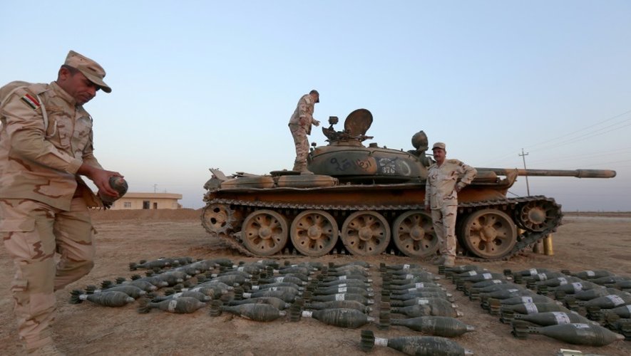 Des soldats irakiens montrent les obus de mortiers près d'un char pris aux jihadistes du groupe EI, à Qaraqosh, à 30 km à l'est de Mossoul
