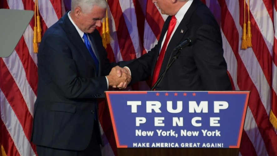 Donald Trump (d) serre la main de son vice président Mike Pence, le 9 novembre 2016 à New York, après avoir été désigné comme le nouveau président américain