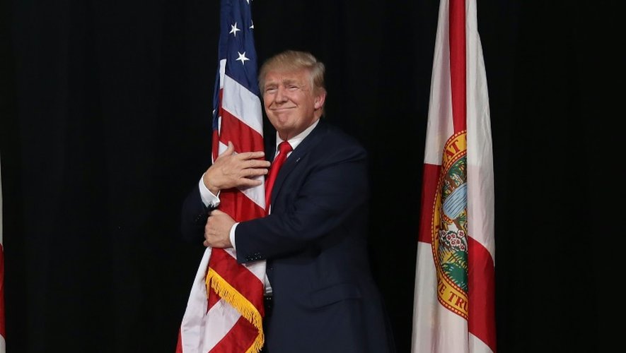 Donald Trump enlace le drapeau américain, le 24 octobre 2016 à Tampa (Floride)