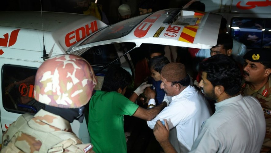 Des pakistanais sortent un blessé d'une ambulance pour le mener vers un hôpital du district de Hub, à environ 40 kilomètres de Karachi, le 12 novembre 2016