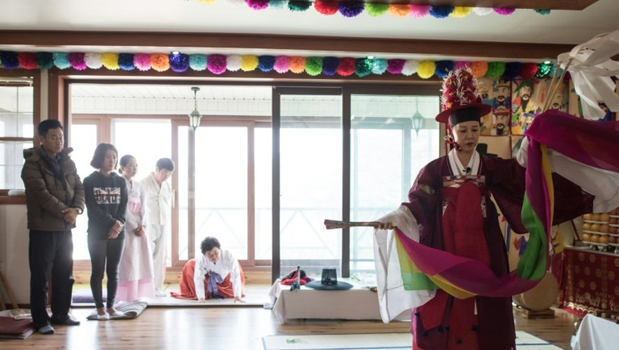 Une chamane Lee Won-Bok (d) s'adonne à un rituel pour un client dans un centre chamanique à Yangju (nord de Séoul), le 8 novembre 2016