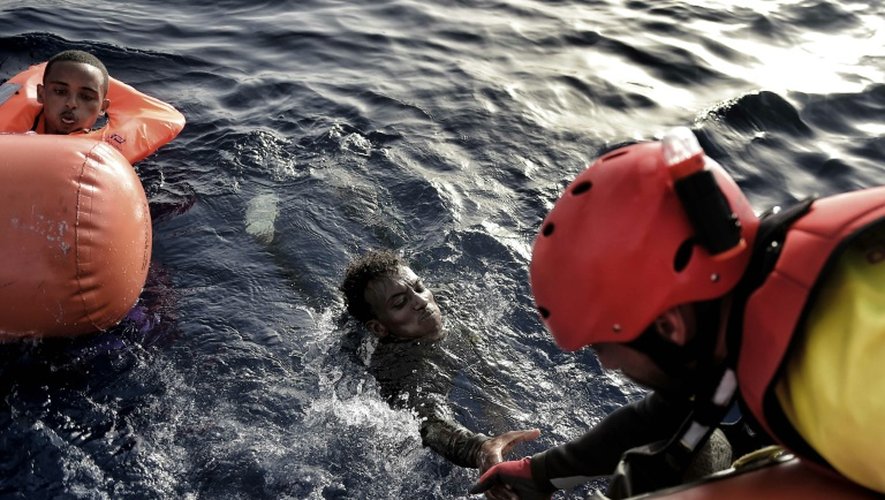Un sauveteur de l'ONG Proactiva Open Arms aide un migrant à sortir de l'eau, le 3 octobre 2016 au large des côtes libyennes