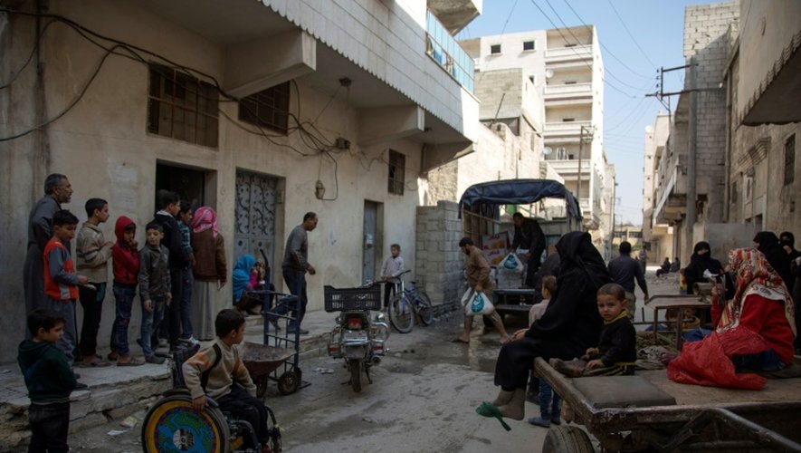 Des civils attendent l'aide alimentaire dans un quartier rebelle d'Alep, le 15 novembre