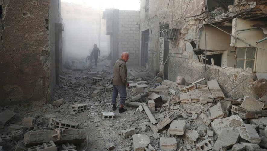 Des habitants recherchent des victimes dans les décombres des immeubles après une frappe aérienne du régime de Damas, le 17 novembre 2016 à Douma, en Syrie