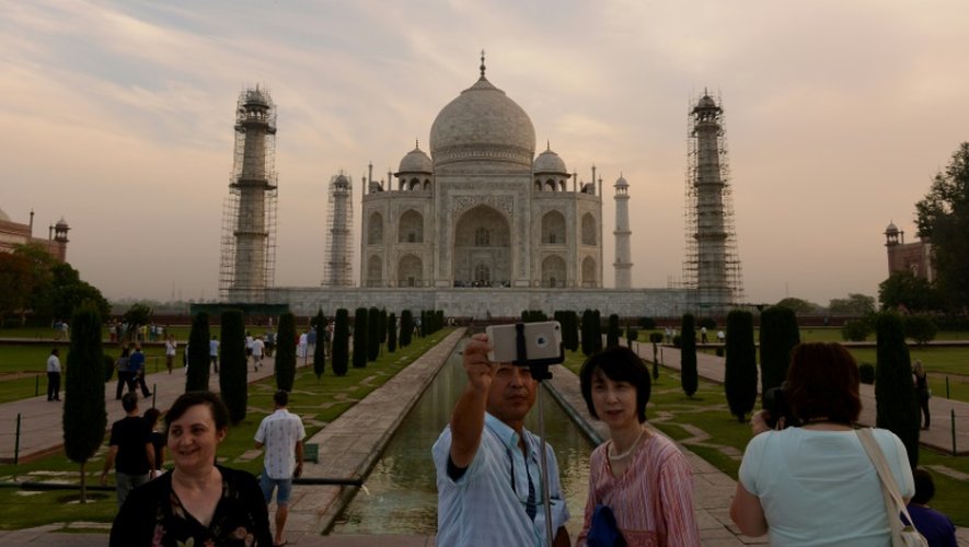Des touristes prennent un selfie devant le Taj Mahal à Agra, le 16 avril 2016