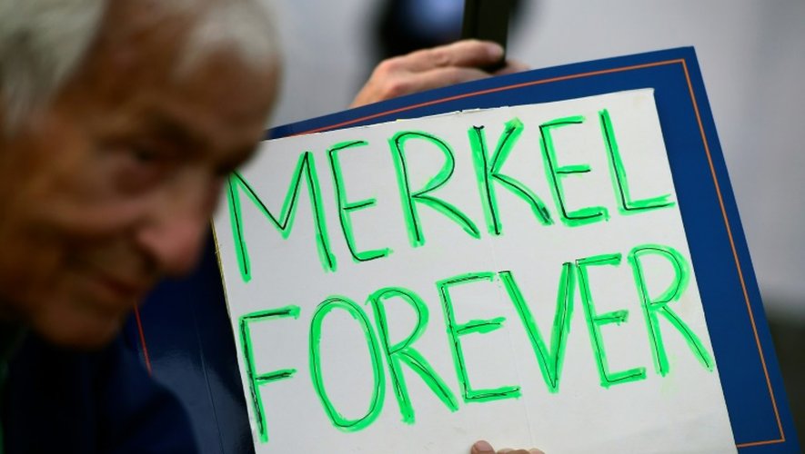 Un partisan d'Angela Merkel portant une pancarte lors d'une réunion politique le 14 septembre 2016 à Berlin