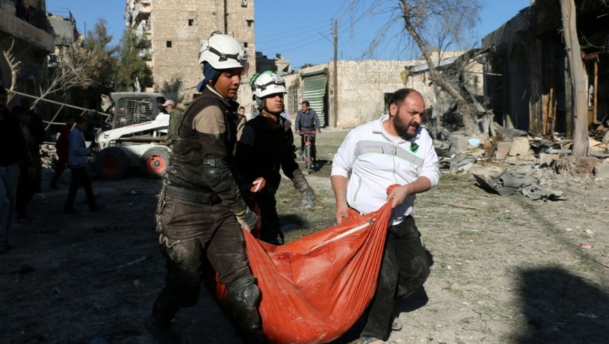 Des Casques blancs syriens transportent le corps d'une victime après une frappes aériennes du régime, le 19 novembre 2016 à Alep