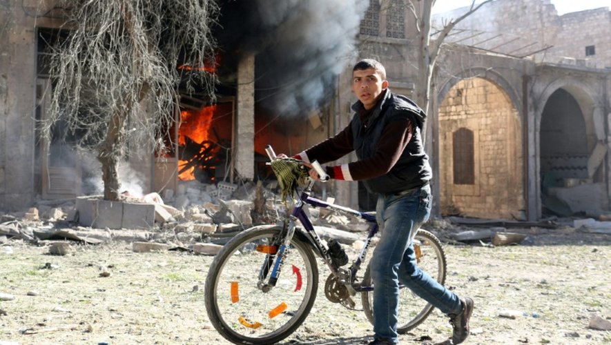 Un jeune syrien pousse son vélo après une frappe aérienne sur un quartier rebelle d'Alep, le 19 novembre 2016