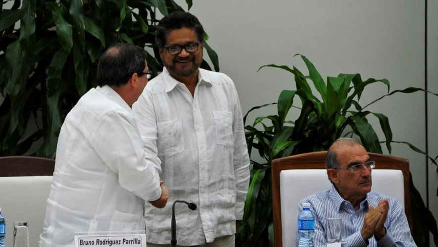 Le ministre cubain des Affaires étrangères Bruno Rodriguez Parrilla (G) serre la main au chef négociateur de la partie des Farc, Ivan Marquez (C) à côté du chef négociateur de la partie gouvernementale, Humberto de la Calle après avoir signé un nouvel accord à La Havane le 12 novembre 2016