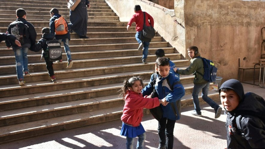 Des enfants pleurent et s'enfuient après que leur école a été touchée par des tirs de roquettes de rebelles, le 20 novembre 2016 à Alep-ouest contrôlé par le gouvernement syrien