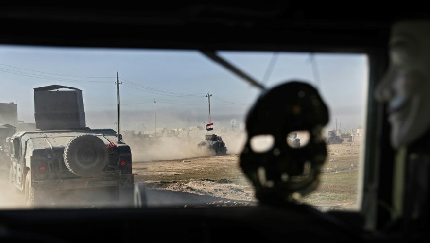 Un masque de crâne et un masque des Anonymous pendent à l'intérieur d'un véhicule blindé des Forces spéciales irakiennes, le 24 novembre 2016 au nord-est de Mossoul