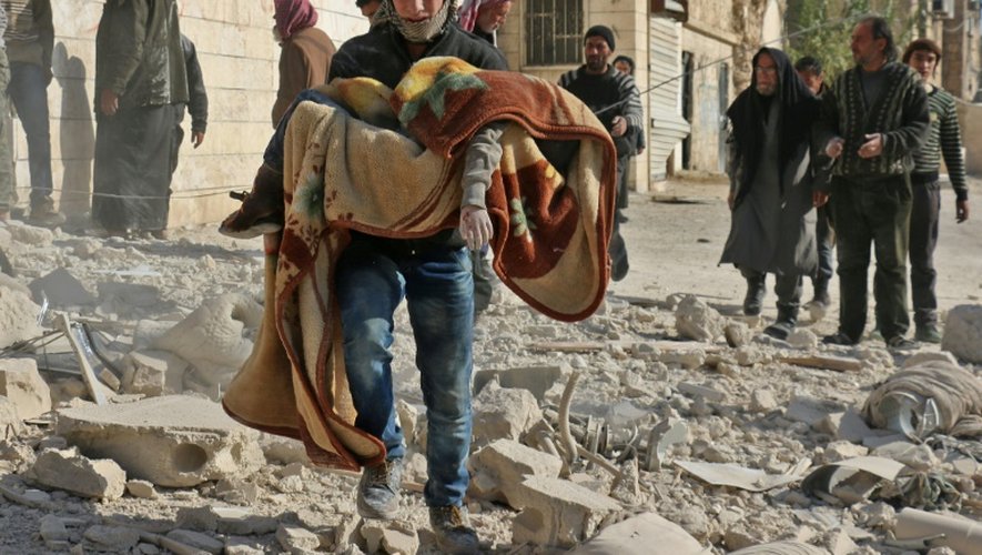 Un secouriste porte le corps d'un garçon après des bombardements à Alep, en Syrie, le 24 novembre 2016