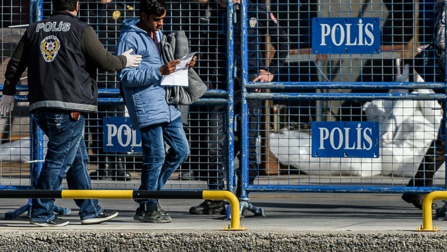 Un policier turc accompagne un migrant rapatrié depuis la Grèce à son arrivée au port d'Izmir, le 4 avril 2016