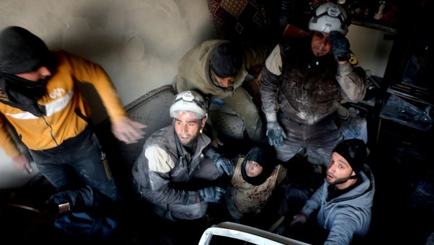 Des Casques blancs syriens évacuent une femme d'un immeuble touché par des frappes aériennes, le 20 novembre 2016 à Alep