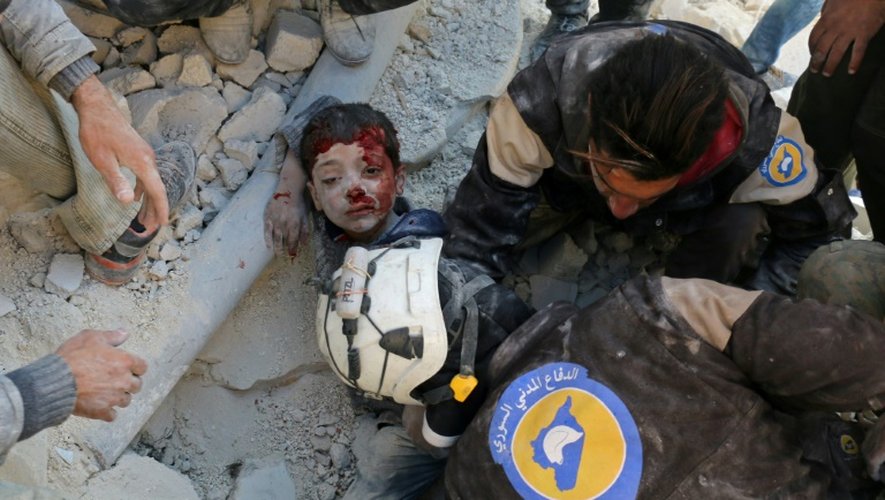 Un sauveteur extrait un enfant ensevelli et blessé par les bombardements sur Alep, le 24 novembre 2016
