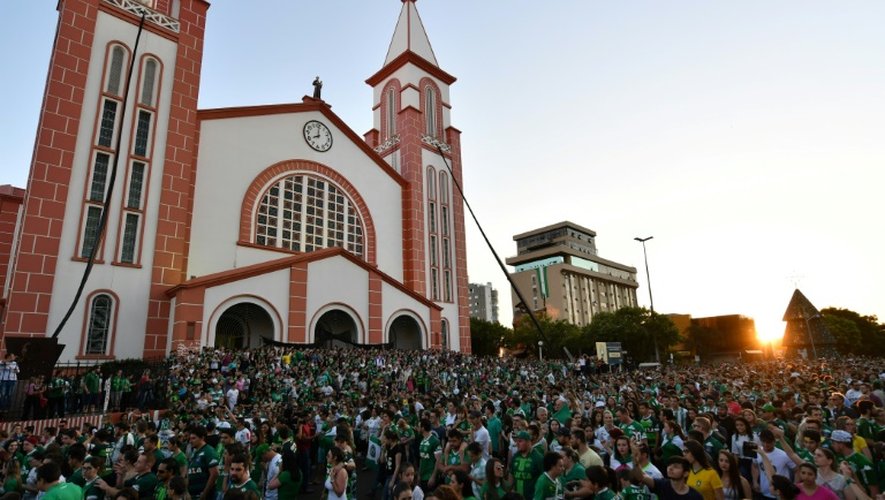 Des brésiliens devant une église de Chapeco lors d'une messe en mémoire des joueurs de l'équipe brésilienne tués dans un accident d'avion dans les montagnes colombiennes, le 29 novembre 2016
