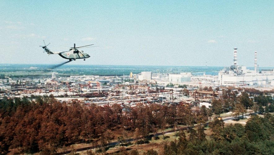 Photo non datée de l'agence Tass montrant un hélicoptère militaire répandant des matériaux censés réduire la contamination radioactive au-dessus de la centrale de Tchernobyl, quelques jours après l'explosion du réacteur numéro 4