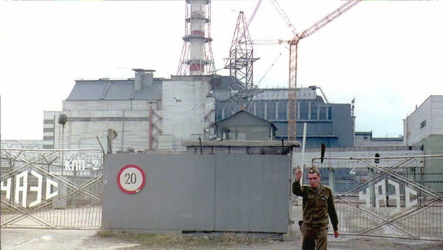 Un agent de sécurité de la centrale de Tchernobyl ordonne à un photographe d'arrêter de prendre des photos au portail d'accès au réacteur accidenté, le 2 décembre 1995