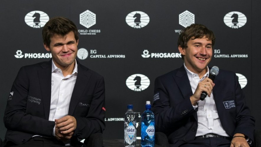 Le joueur d'échecs norvégien Magnus Carlsen, (G) sacré champion du monde, aux côtés de son adversaire le Russe Sergey Karjakin, le 30 novembre 2016 à New York