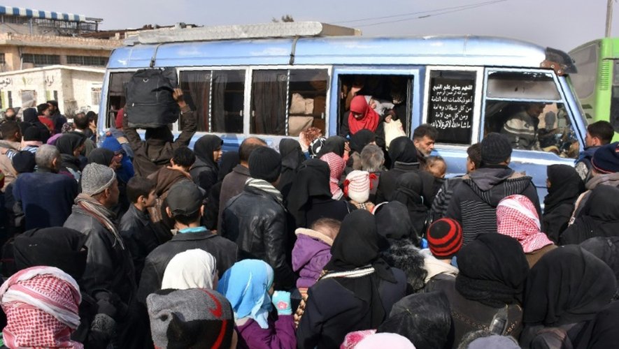 Des familles qui ont fui les quartiers est d'Alep montent le 30 novembre 2016 à bord d'un bus du régime syrien  à Jabal Badro