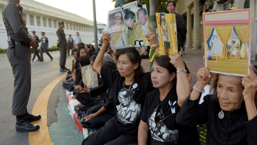 Des femmes brandissent des portraits du nouveu roi de Thaïlande et de son père défunt, le 1er décembre 2016 près du grand palais de Bangkok
