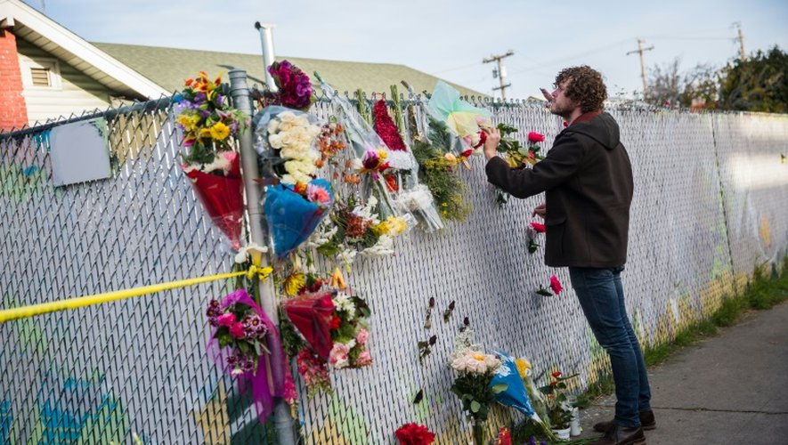 Une personne venue se recueillir devant un mémorial à la mémoire des vctimes, le 4 décembre 2016 à Oakland