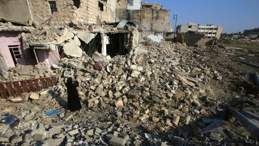 Une Syrienne photographie les ruines dans le quartier où elle avait habité, le 4 décembre 2016 à Alep, en Syrie
